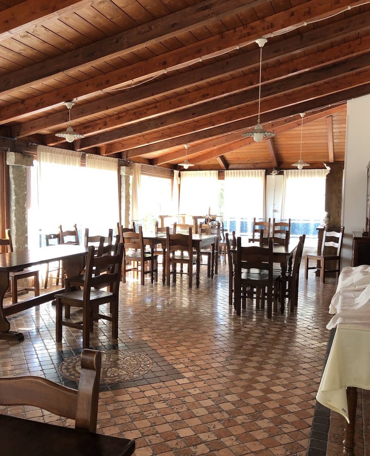La sala da pranzo dell'agriturismo con travi in legno